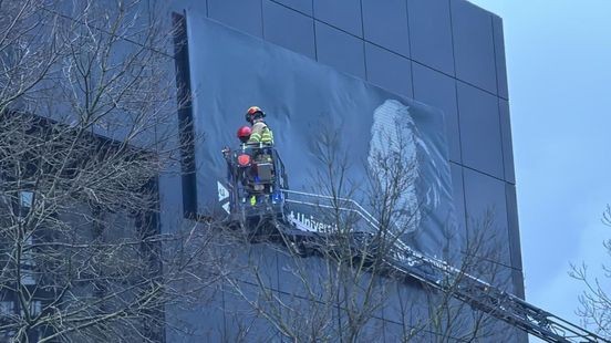 Stormschade: bord aan gevel UM-gebouw hangt los